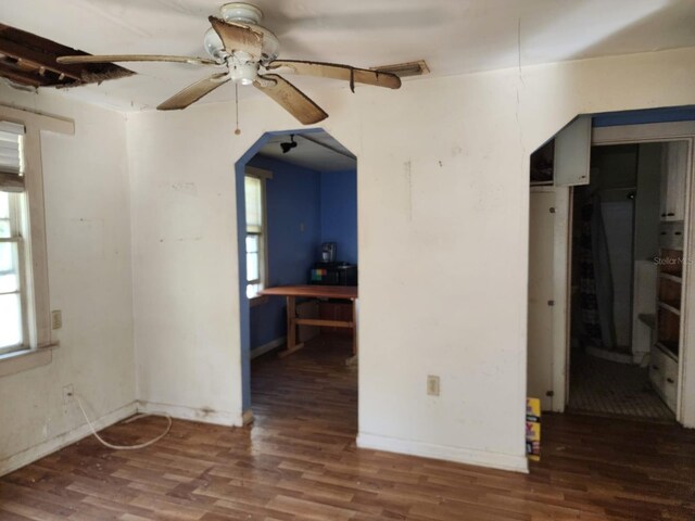 spare room featuring plenty of natural light, dark wood-type flooring, and ceiling fan