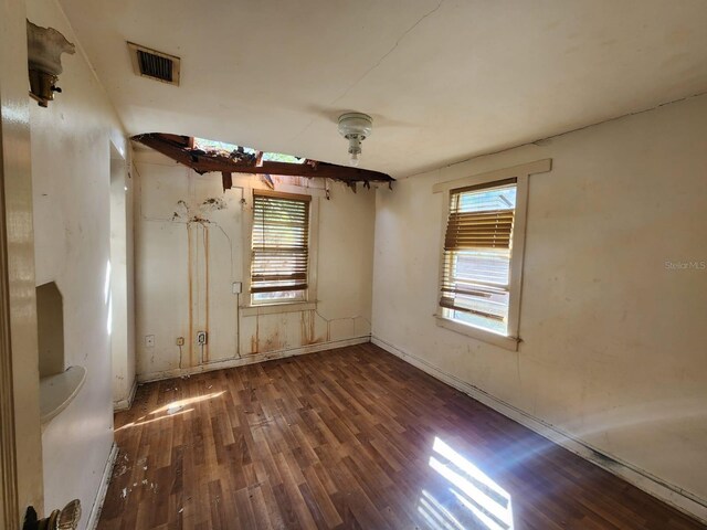 unfurnished room with a wealth of natural light and dark hardwood / wood-style floors