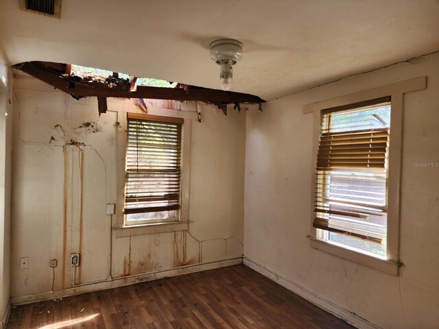 unfurnished room with dark wood-type flooring and plenty of natural light