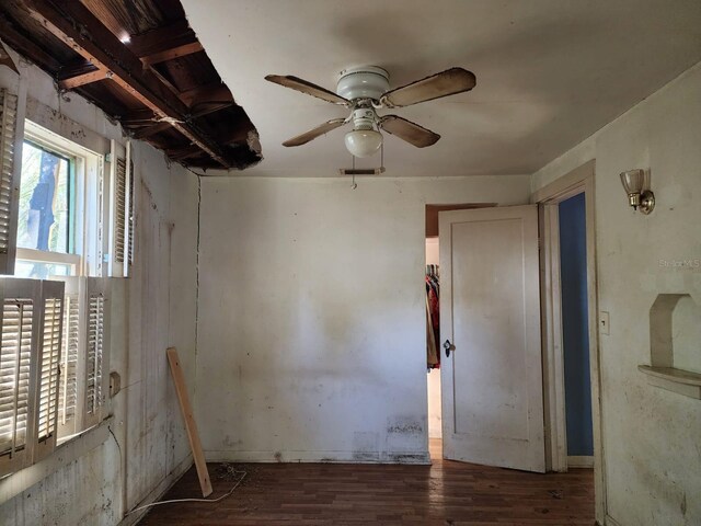 empty room with dark wood-type flooring and ceiling fan