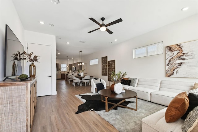 living room with light wood-type flooring and ceiling fan