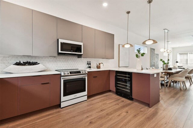 kitchen featuring light hardwood / wood-style floors, kitchen peninsula, beverage cooler, range with electric stovetop, and pendant lighting