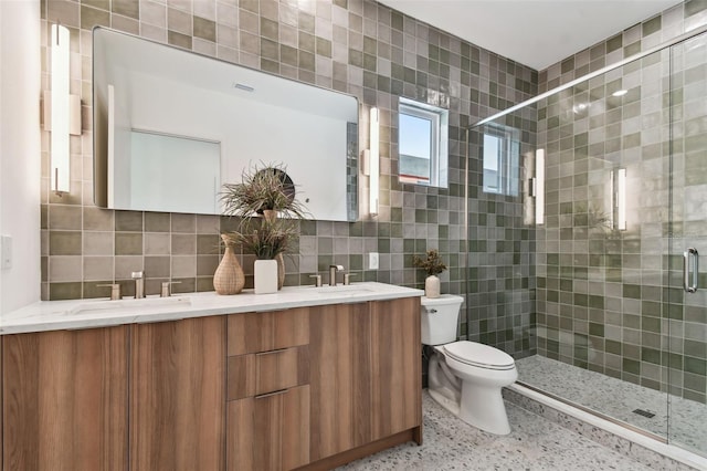 bathroom featuring tile walls, vanity, tasteful backsplash, and a shower with door