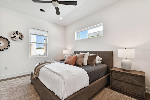 bedroom featuring hardwood / wood-style floors, ceiling fan, and multiple windows