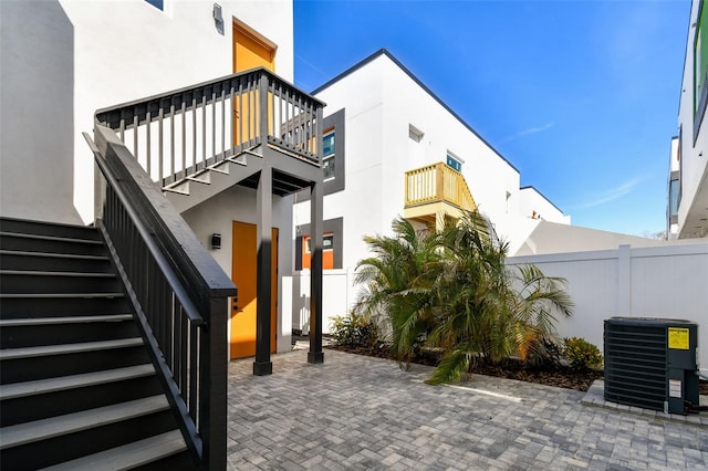 view of exterior entry featuring cooling unit and a patio