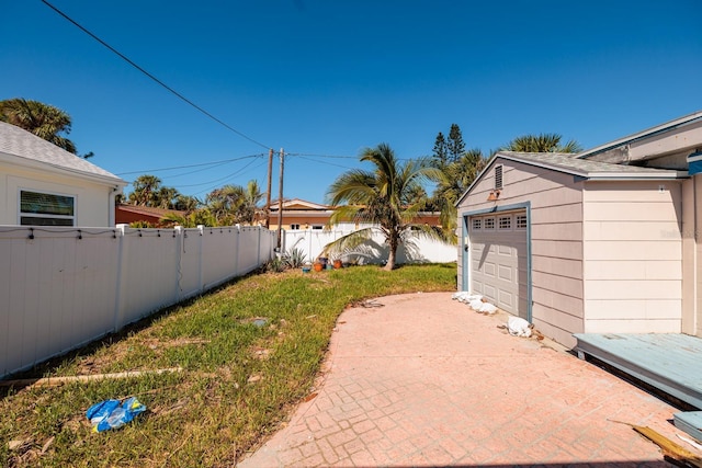 view of yard with a garage and an outbuilding