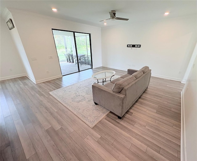 living room featuring crown molding, ceiling fan, and light hardwood / wood-style flooring