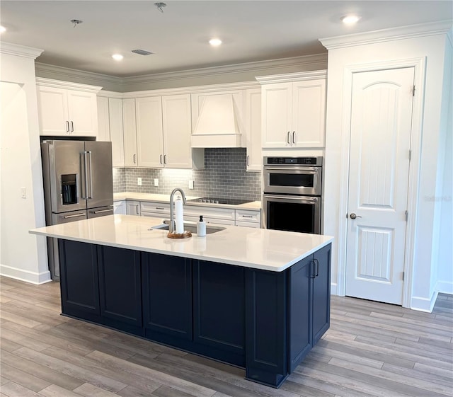 kitchen featuring white cabinetry, appliances with stainless steel finishes, sink, and an island with sink