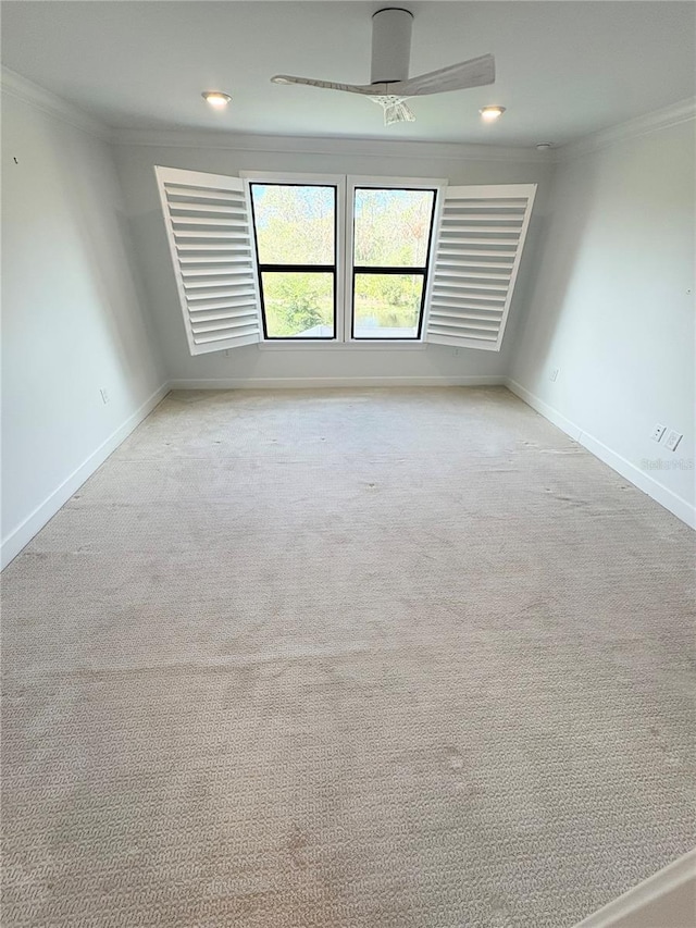 carpeted spare room with ceiling fan and crown molding