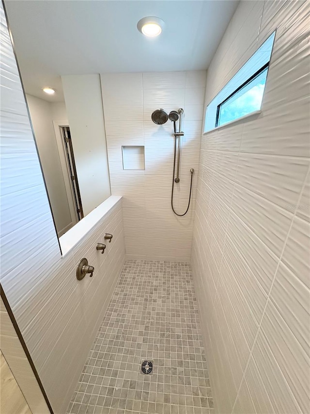 bathroom with tile walls and a tile shower