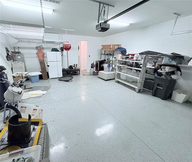 garage with a garage door opener and white fridge