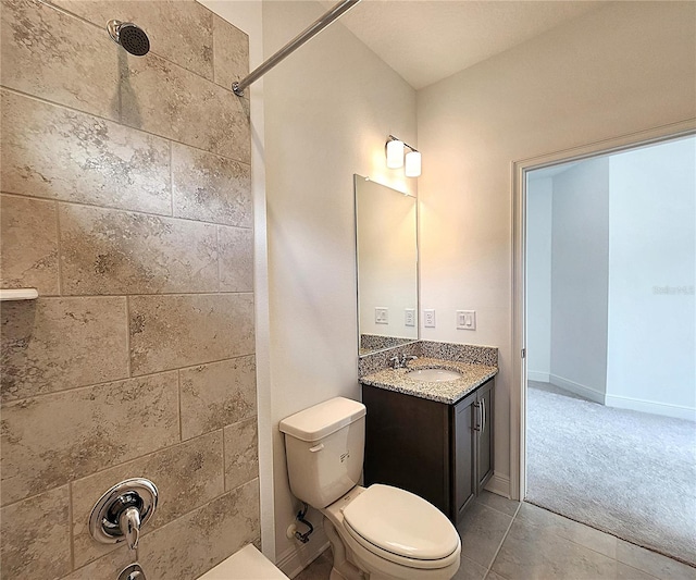 bathroom featuring tile patterned flooring, vanity, toilet, and a tile shower