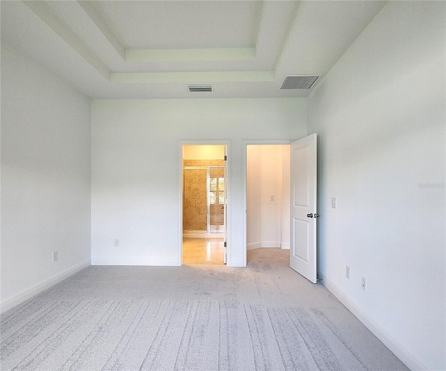 carpeted spare room with a tray ceiling