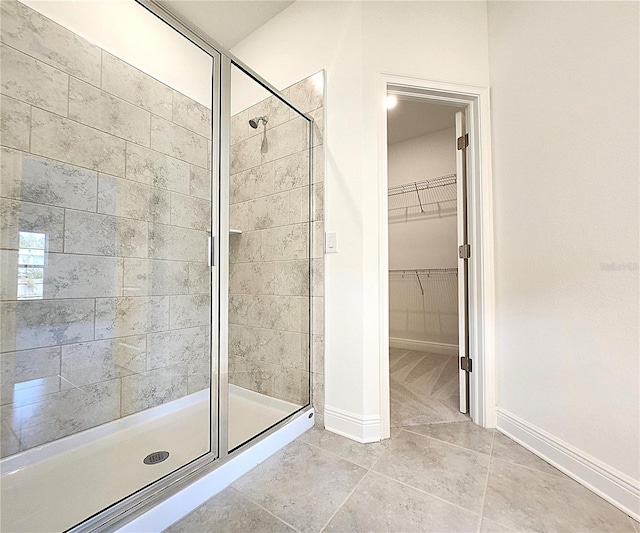 bathroom with walk in shower and tile patterned flooring