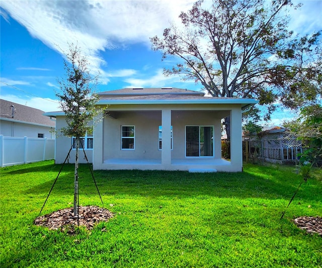 back of property with a lawn and a patio area