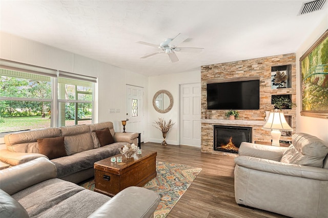 living room featuring ceiling fan, dark hardwood / wood-style floors, and a fireplace