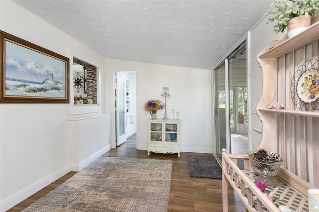 interior space with a textured ceiling, dark hardwood / wood-style floors, and vaulted ceiling