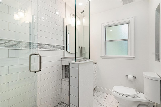 bathroom featuring toilet and a shower with shower door