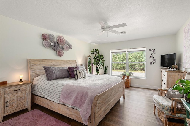 bedroom featuring hardwood / wood-style flooring, ceiling fan, and a textured ceiling