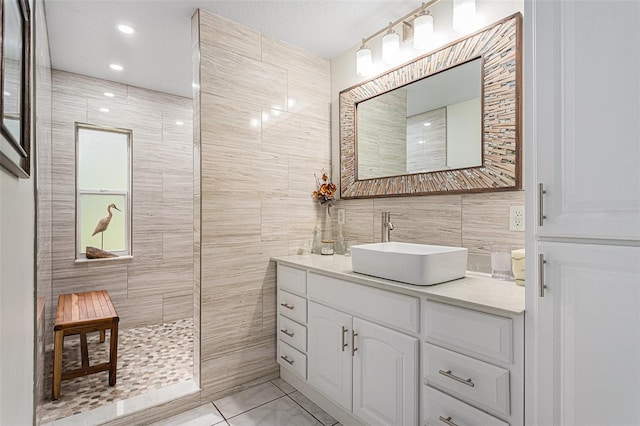 bathroom with tile walls, walk in shower, and vanity