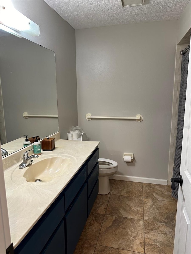 bathroom with vanity, a textured ceiling, and toilet