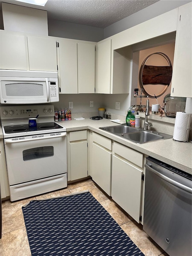 kitchen with white cabinets, a textured ceiling, white appliances, and sink