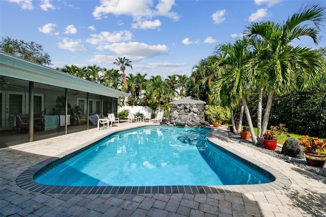 view of pool with a patio and a sunroom