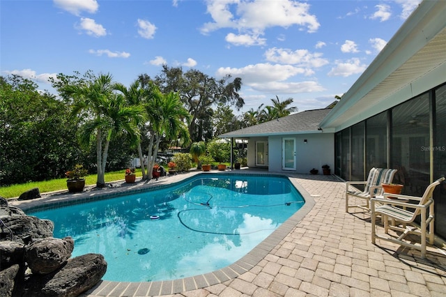 view of pool with a sunroom and a patio