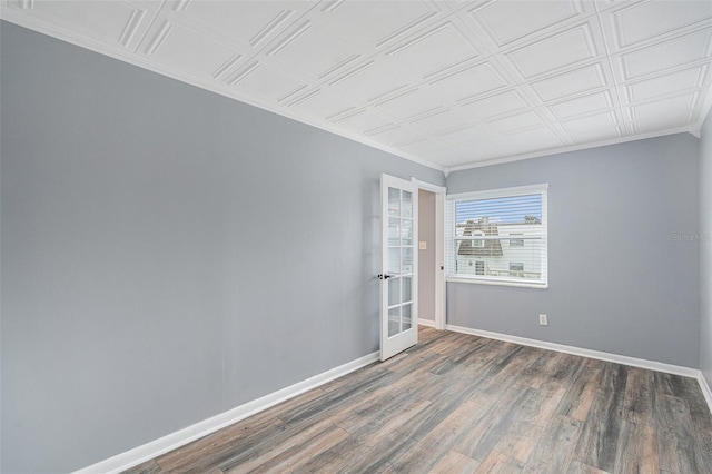 spare room featuring ornamental molding, french doors, and dark wood-type flooring