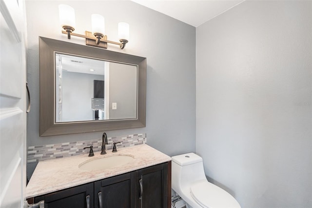 bathroom featuring decorative backsplash, vanity, and toilet