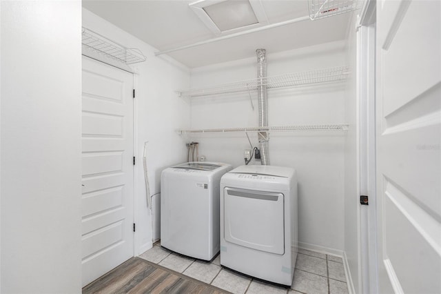 laundry area featuring washing machine and dryer and light hardwood / wood-style flooring