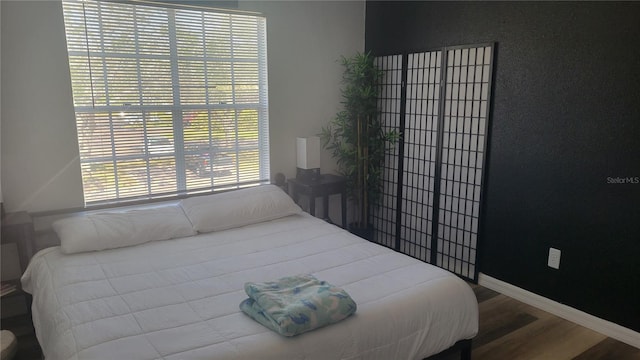 bedroom with hardwood / wood-style floors and multiple windows