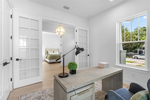 office space featuring french doors and light hardwood / wood-style floors