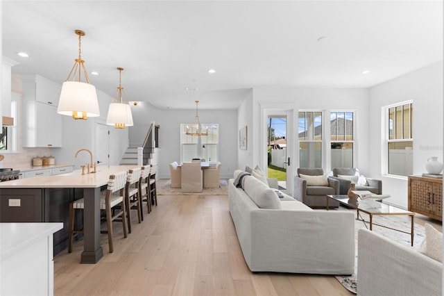 living room featuring an inviting chandelier and light hardwood / wood-style flooring