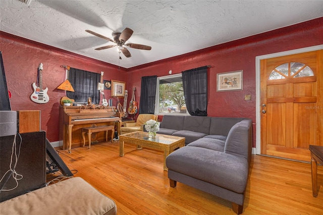 living room with ceiling fan, wood-type flooring, and a textured ceiling