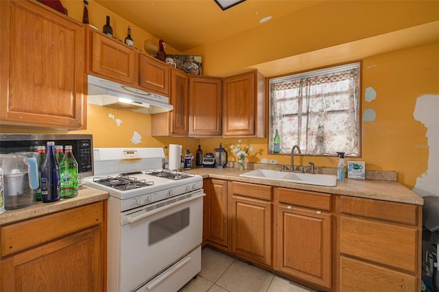 kitchen featuring gas range gas stove, light tile patterned floors, and sink