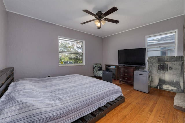 bedroom with light hardwood / wood-style floors and ceiling fan