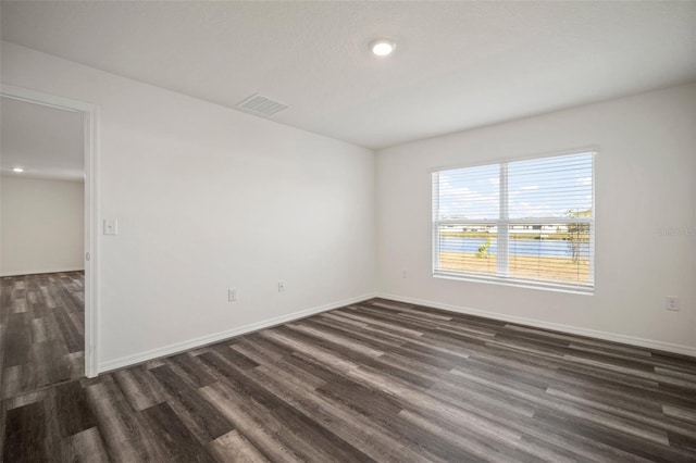 spare room with dark wood-type flooring