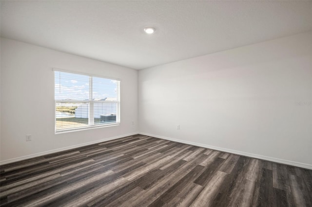 unfurnished room with a textured ceiling and dark hardwood / wood-style flooring