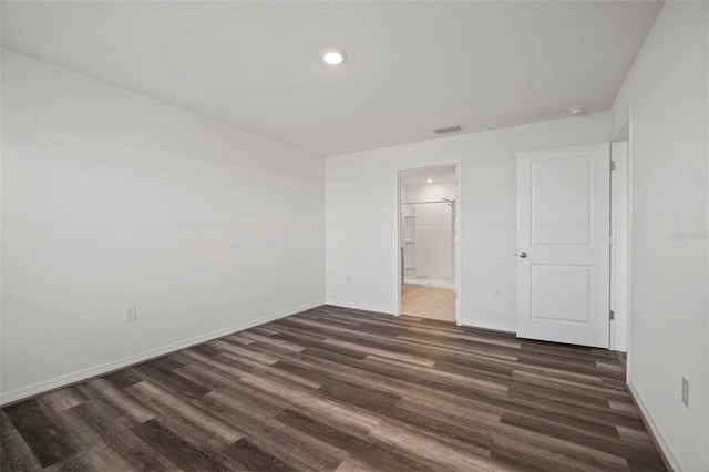 unfurnished bedroom with dark hardwood / wood-style floors and ensuite bath