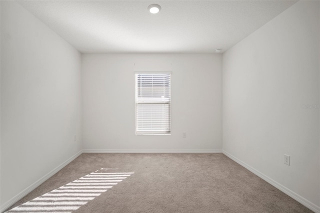 unfurnished room featuring light colored carpet