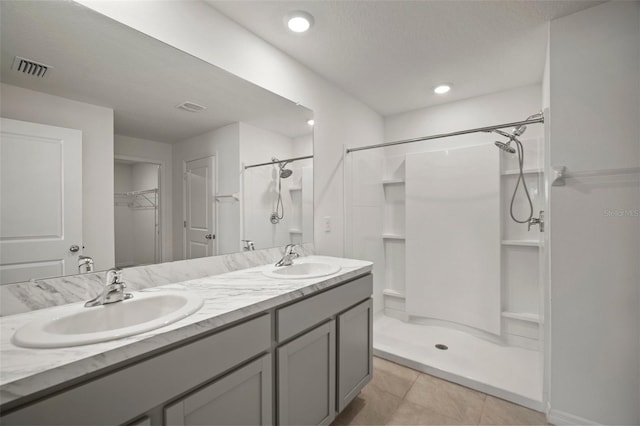 bathroom featuring a shower, tile patterned floors, and vanity