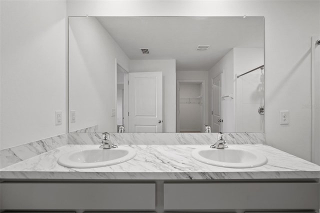 bathroom featuring walk in shower and vanity