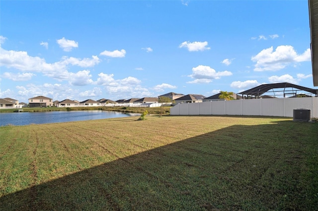 view of yard with central air condition unit and a water view