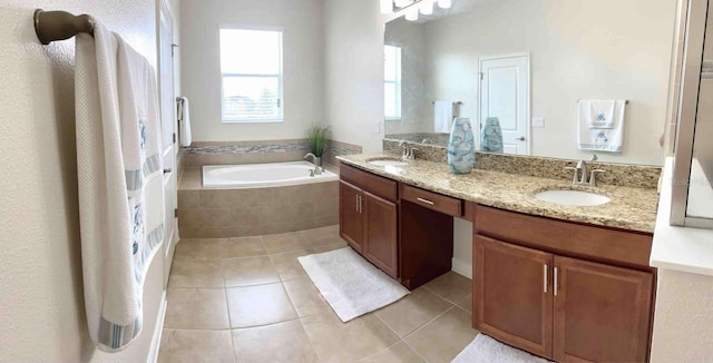 bathroom with tiled bath, tile patterned flooring, and vanity