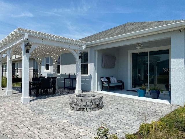 view of patio / terrace with a pergola, ceiling fan, and an outdoor fire pit