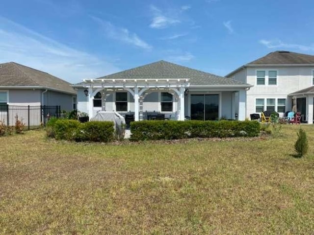 rear view of house with a pergola and a lawn