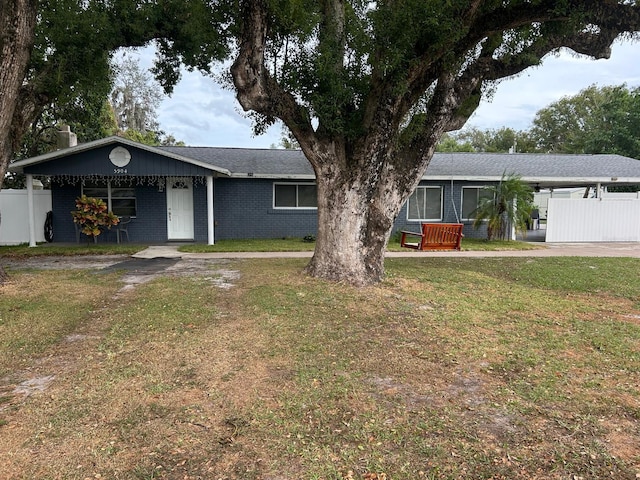 ranch-style house featuring a front yard and a carport