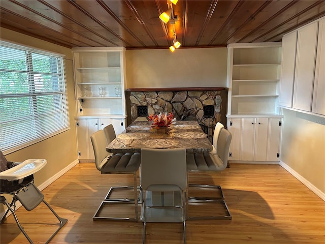 dining area with ornamental molding, light hardwood / wood-style floors, and wood ceiling