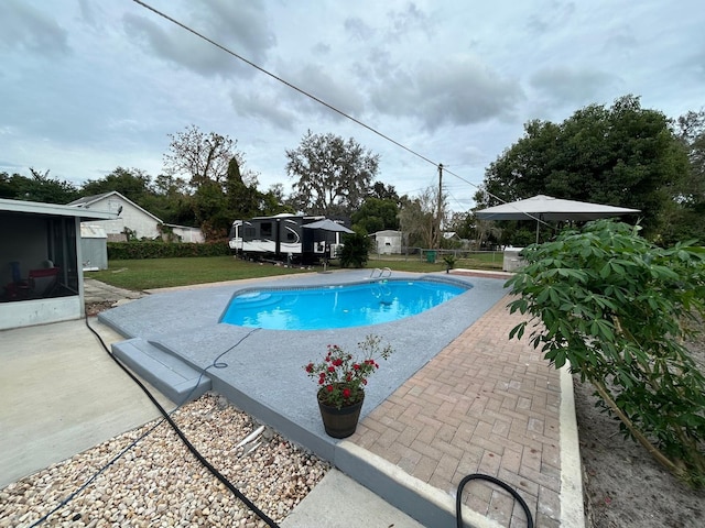 view of pool with a patio area and a yard